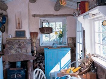 
Dyanna’s cabin clings to its rocky perch over the Pecos River with a thick stone foundation. Wide planks, finished in whitewash, complete the flooring in this room.
